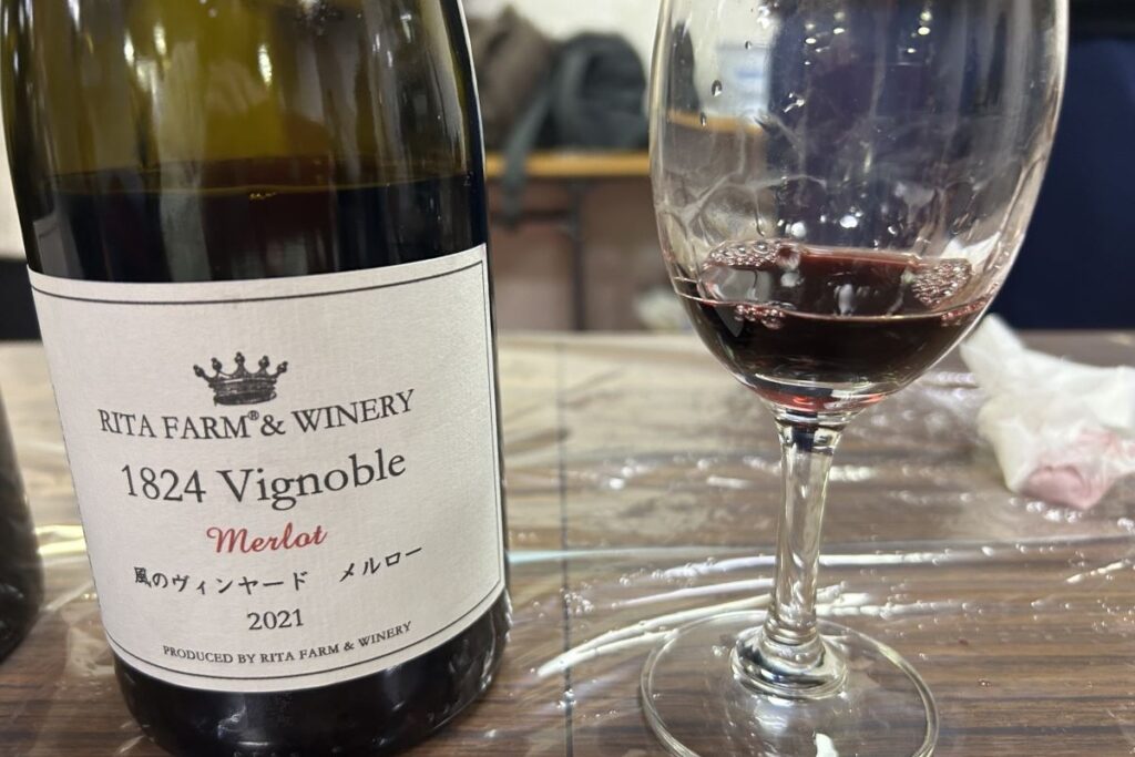 リタファーム&ワイナリーの風のヴィンヤードメルロー2021のボトルと注がれたグラス
