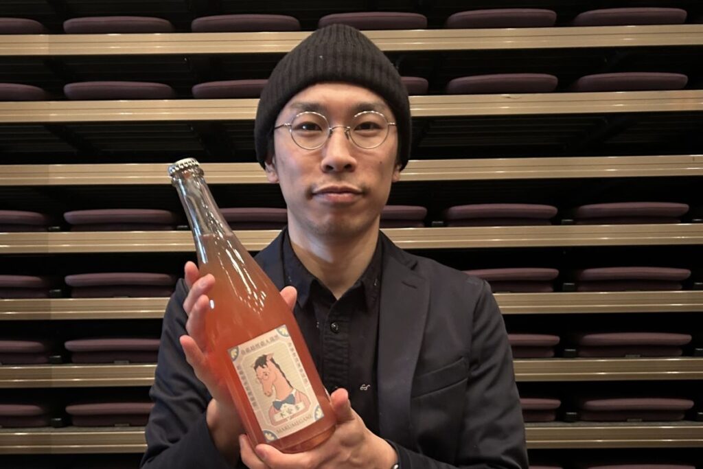 ボトルを手にするドメーヌマルメガネの大野崇さん