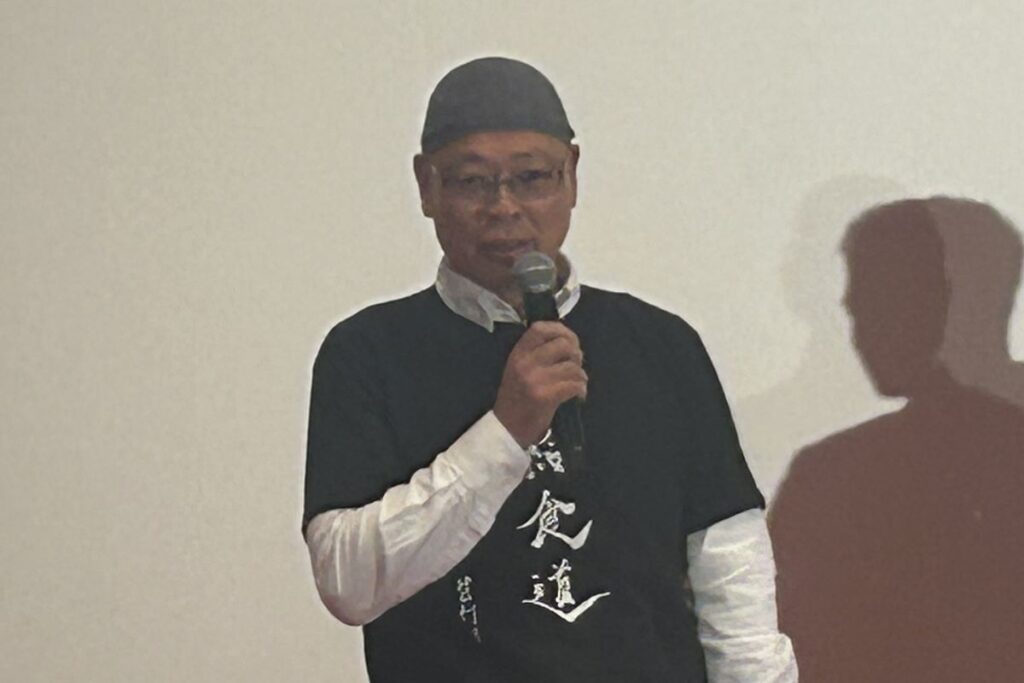 舞台でマイクを手に映画について語る岩淵プロデューサー