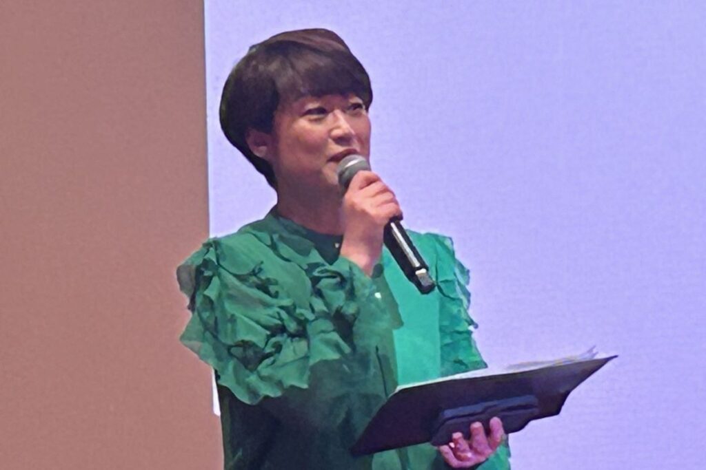 舞台でマイクを手に映画について語る司会の北川久仁子さん