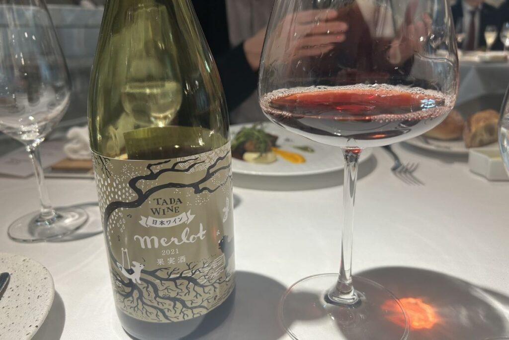 肉料理に合わせた多田農園のワインと注がれたグラス