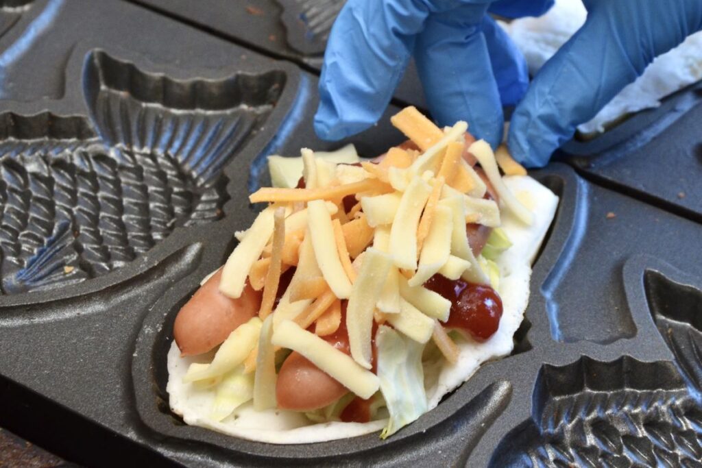 ユトリノハナの日替わりメニューで、大きなウインナーにチーズがたっぷりの「ホットドックチーズ」