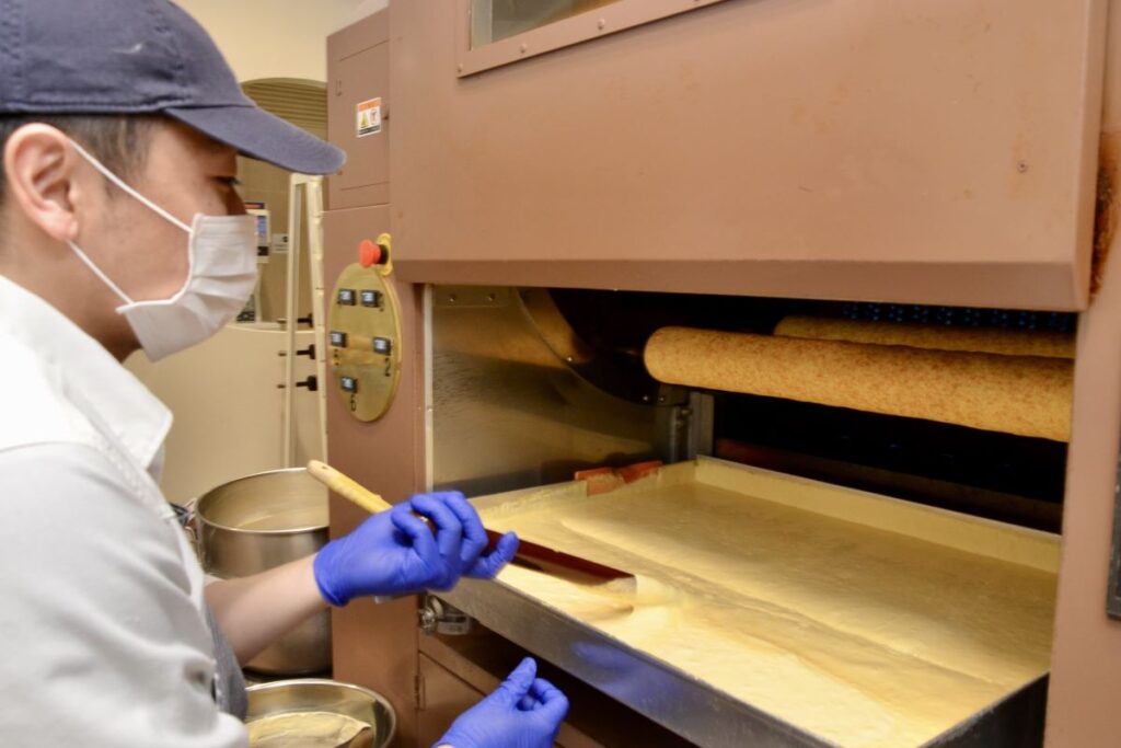 水分量の多い生地を薄く付けて手作業で焼くのを丁寧に繰り返して焼かれるring ringのバウムクーヘン焼成作業