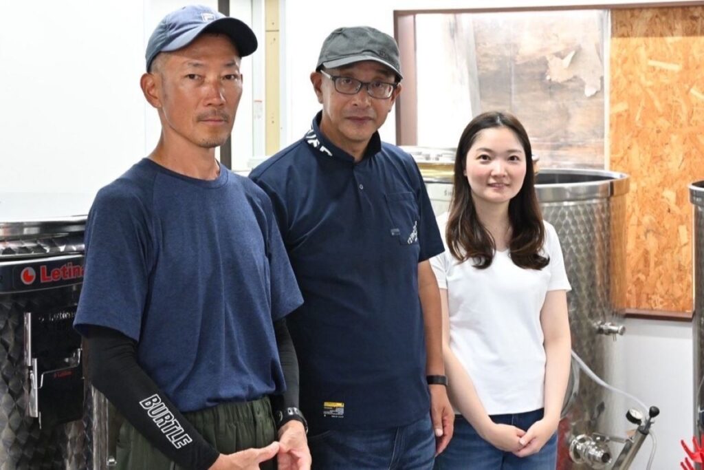 ベリーベリーファーム＆ワイナリー仁木の醸造タンクの前に並ぶ（左から）福光さん、山口さん、三浦さん
