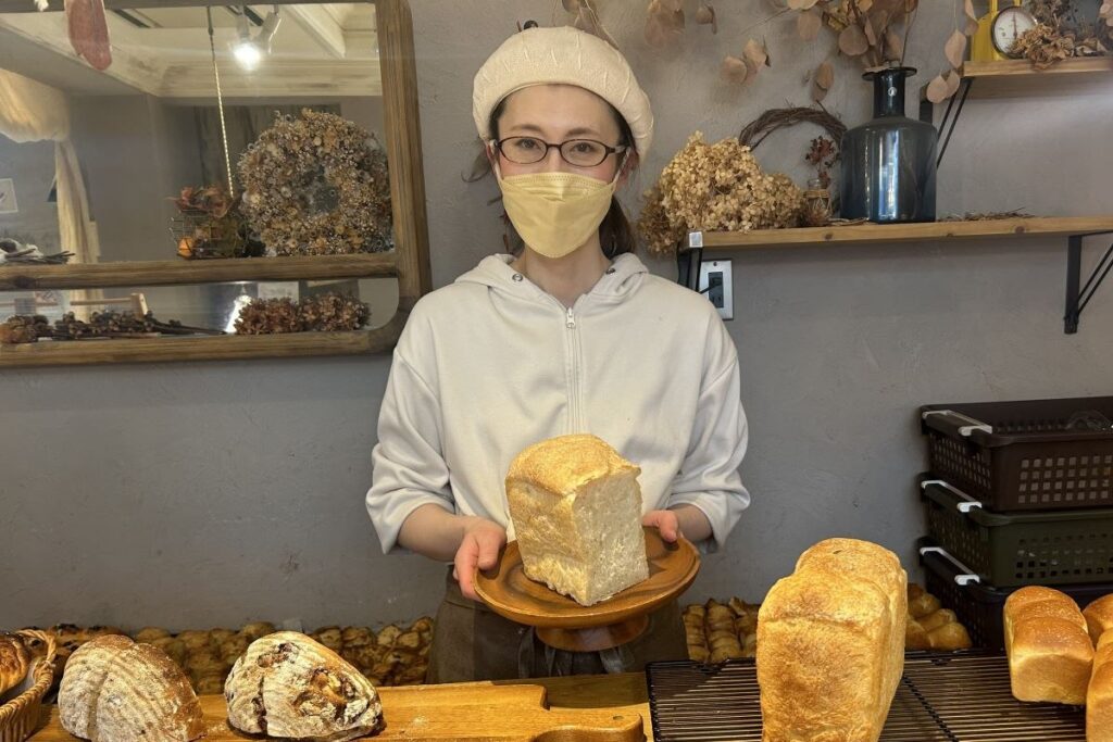 一番人気の食パンを手にするマネージャーの平井さん