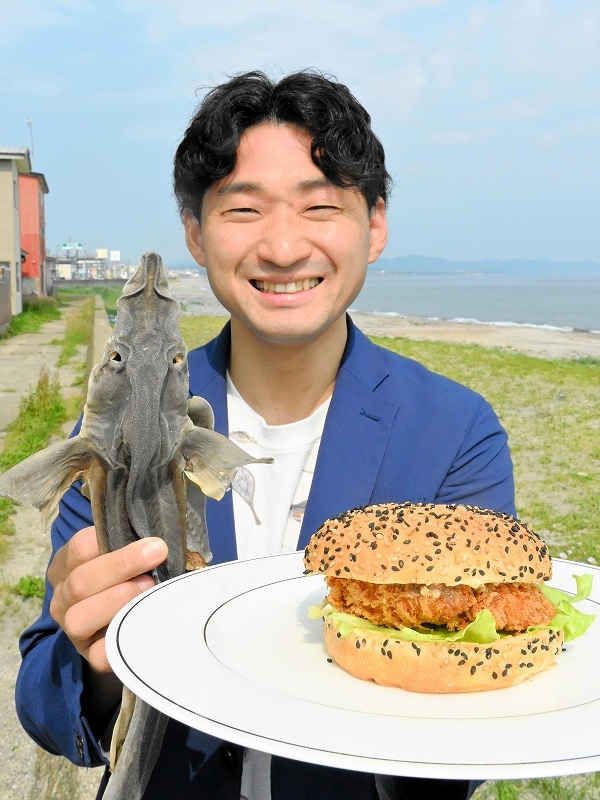 お皿に乗せた「函館サメフライバーガー」をPRする福田海産の斉藤いゆさん