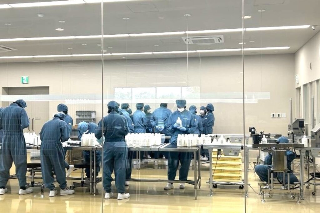 包装室で最後の点検をしながら作業を進める製造スタッフら